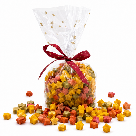 Weihnachtliche Geschenk-Tüte mit rotem Schleifenband und bunten Stern-Konfetti